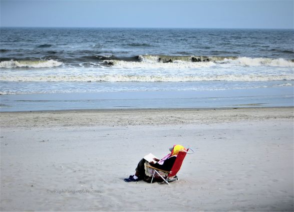 person resting in beach chair at surfside